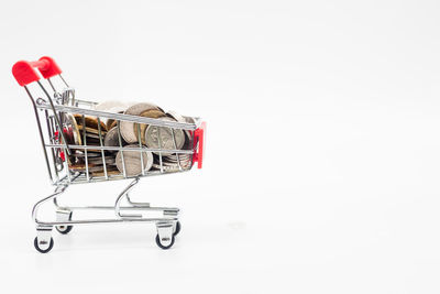 Close-up of shopping cart against white background