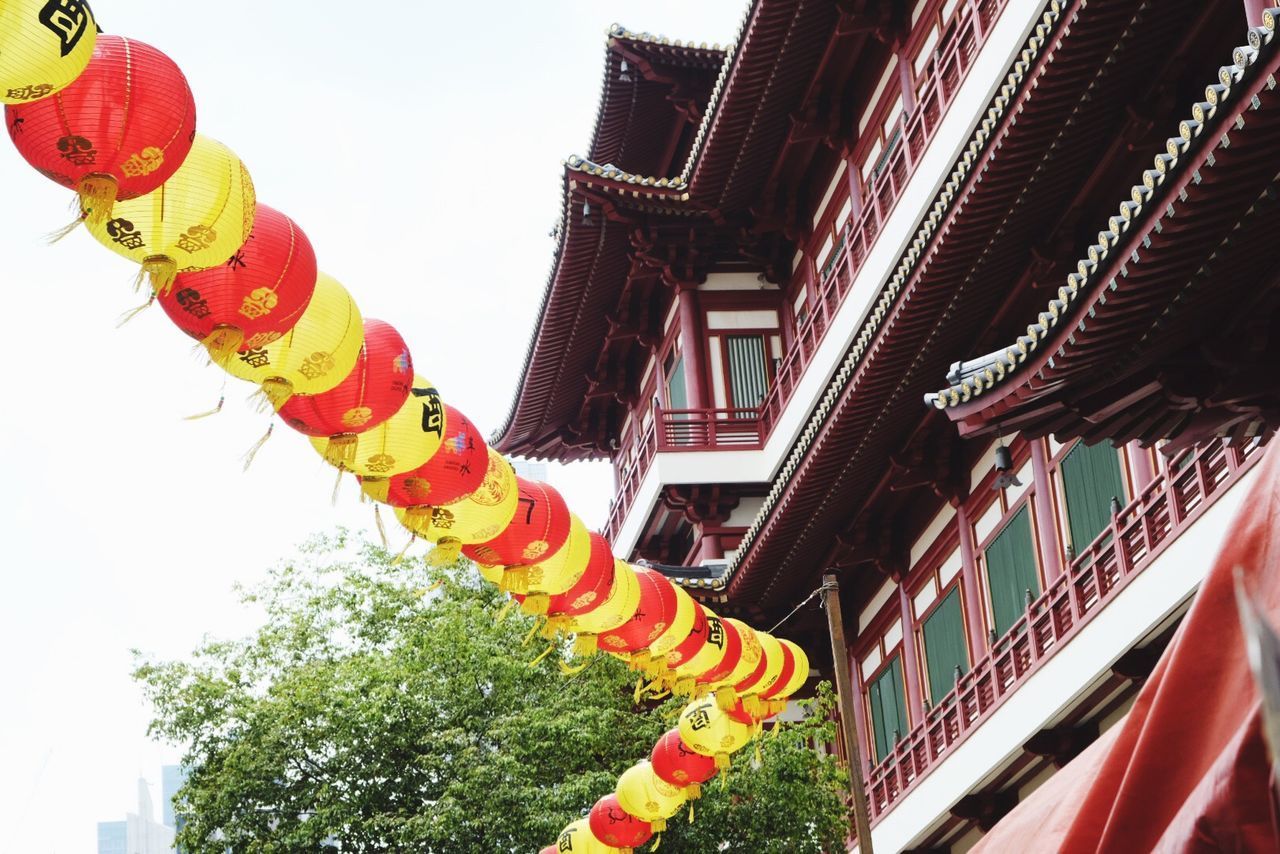 LOW ANGLE VIEW OF MULTI COLORED LANTERNS HANGING ON BUILDING