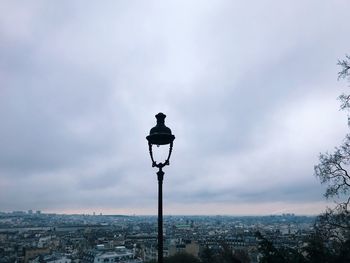 Street light in city against sky