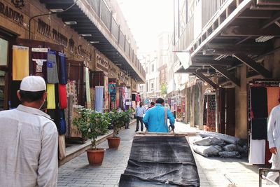 Rear view of people walking on street market
