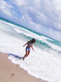 Full length of woman on beach against sky