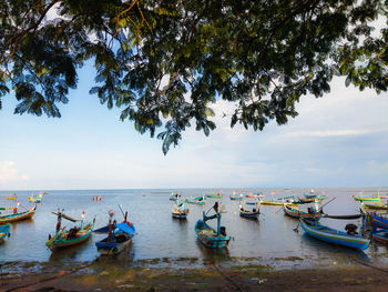 A collection of trawler fishing boats in sea against sky