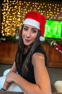 Portrait of a young female smiling after getting a vaccine - woman showing her arm with plaster