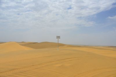 Scenic view of sand dunes against sky