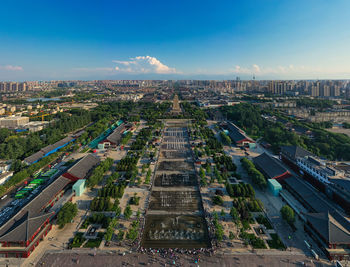 High angle view of buildings in city against blue sky