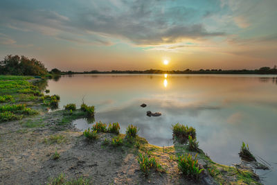 Scenic view of lake against sky during sunset