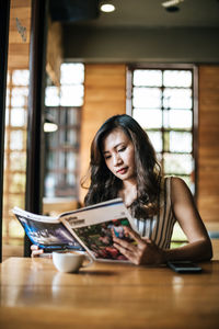 Portrait of young woman sitting on table