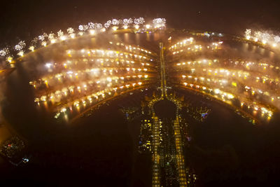 Illuminated ferris wheel against sky at night