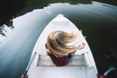 High angle view of girl sitting on boat in lake