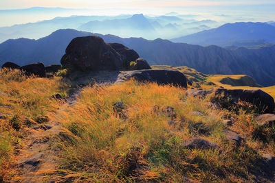 Scenic view of land and mountains against sky