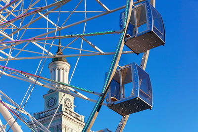 A beautiful and scenic view of the empty cabins of the ferris wheel against the blue sky.