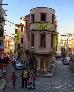 People walking on street amidst buildings in city