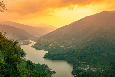 Mountain river leading to the valley at dawn with dramatic sky