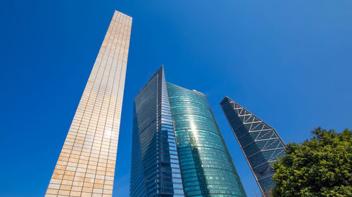 Low angle view of modern buildings against blue sky