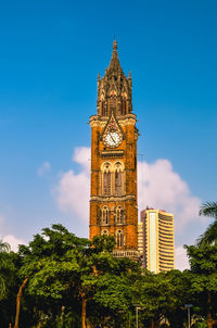 Low angle view of clock tower against blue sky