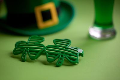 Close-up of green clover shaped sunglasses on table