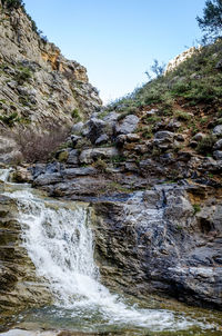 Scenic view of waterfall against sky