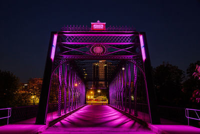 Illuminated bridge against sky at night