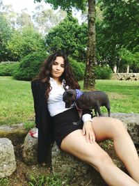 Portrait of young woman sitting on tree