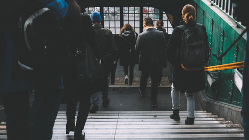 Rear view of people walking on steps in city