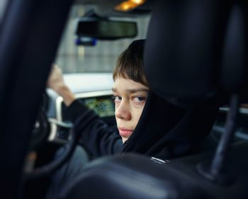 Portrait of teenage boy driving car