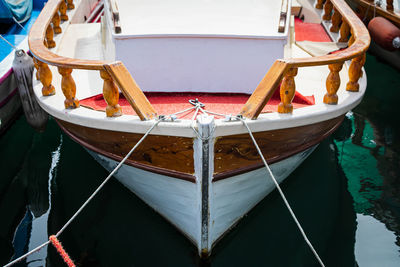 Wooden side of the boat, painted white and brown, with a beautiful wooden fence 