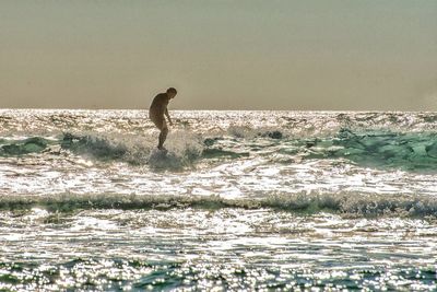 Full length of man standing on beach against sky