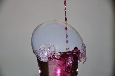 Liquid falling in glass with bubble against wall