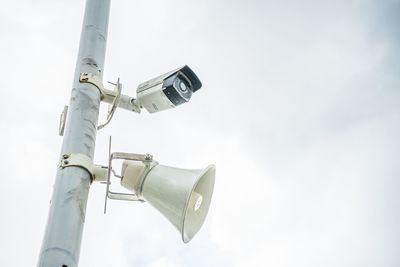 Low angle view of security camera against sky