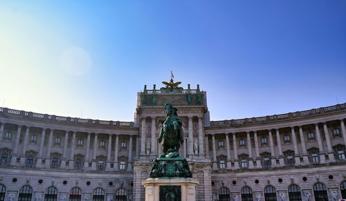 Low angle view of statue in city against clear sky