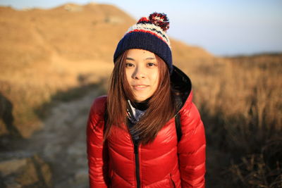 Portrait of smiling young woman standing in snow