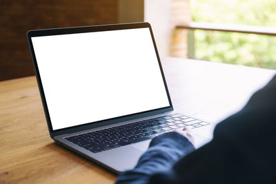 Low section of person using laptop on table