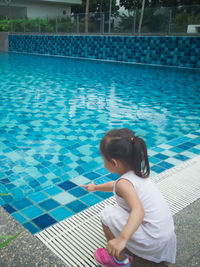 Little asian toddler baby have a fun with a splash near swimming pool