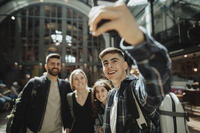 Happy boy taking selfie with family at station