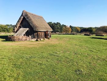 House on field against clear sky