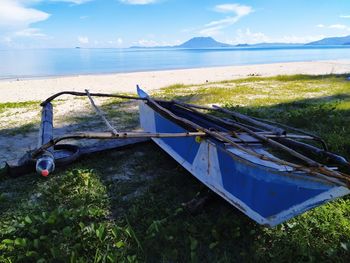 Fishing boat on sea shore against sky