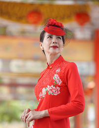 Woman looking away while standing outdoors