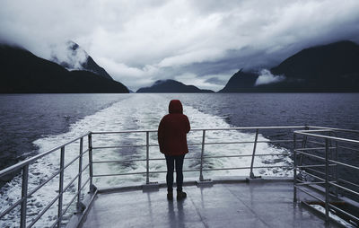 Rear view of person standing on deck of boat