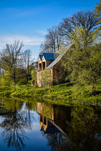 Building by lake against sky