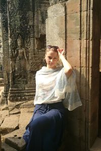 Young woman sitting outdoors of historic building