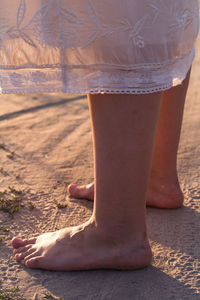 Close up female bare feet standing on sand concept photo