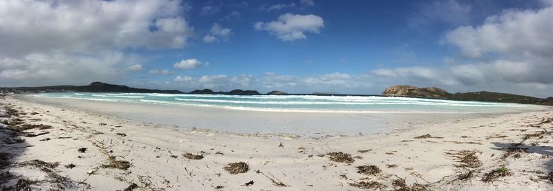 View of calm beach against blue sky