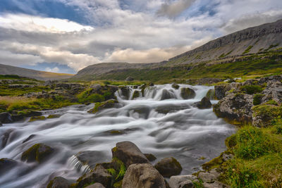 Scenic view of waterfall against sky