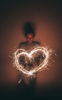 View of woman with fire crackers at night