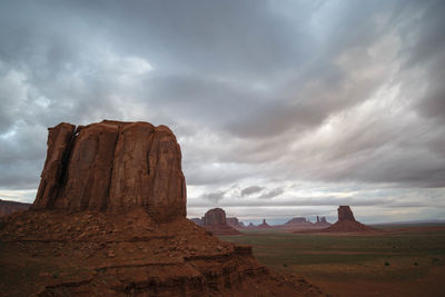 Rock formations on landscape against cloudy sky