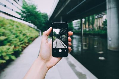 Cropped image of hand holding smart phone