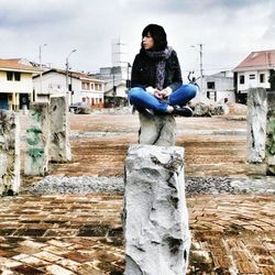 Full length of woman standing by building against sky