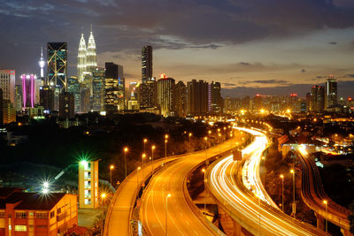 High angle view of illuminated street amidst buildings at night