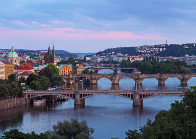 Bridge over river in city against sky