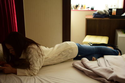 Woman lying on bed at home